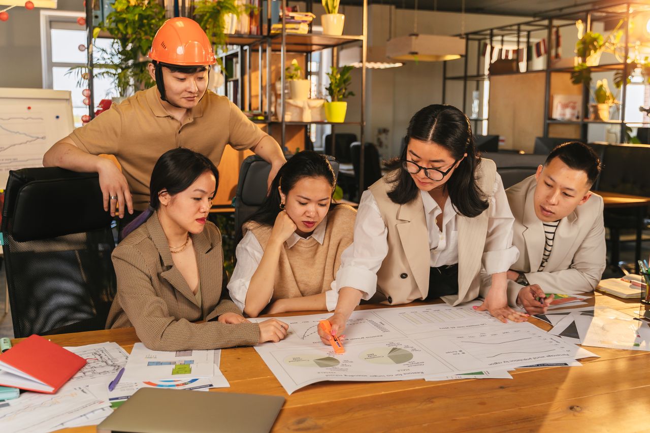 The Art of Drawing Readers In: Your attractive post title goes here A diverse team of professionals working together on architectural plans in a modern office setting.